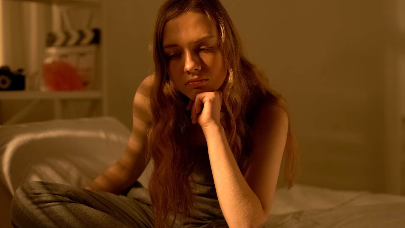 sad girl sitting alone on her bed